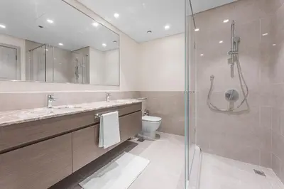 a bathroom with a shower and a sink and a toilet at Forte Tower 1 in Dubai