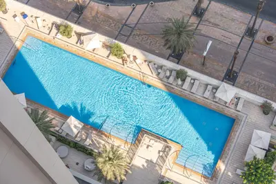 an overhead view of a large swimming pool with palm trees at Forte Tower 1 in Dubai