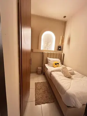 a small bedroom with a bed with a yellow pillow on it at Adaz Home in Dubai