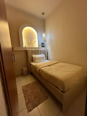 a small bedroom with a bed and a window at Adaz Home in Dubai