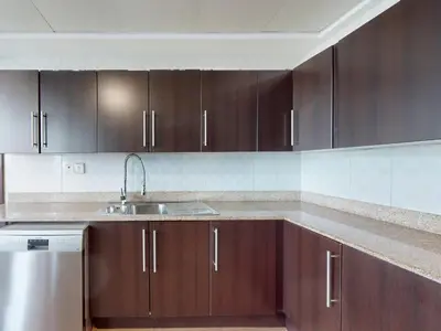 a kitchen with wooden cabinets and a sink at Spacious Duplex 4BR with Maids Room in Dubai