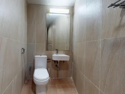 a bathroom with a toilet and a sink and a mirror at Spacious Duplex 4BR with Maids Room in Dubai
