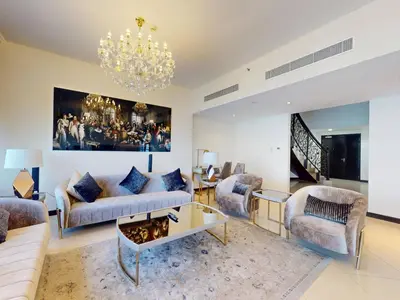 a living room with a couch and a chandelier at Spacious Duplex 4BR with Maids Room in Dubai