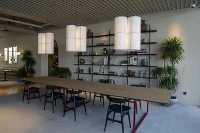 a table and chairs in a room with a book shelf at Modern Studio at Upside Living with Burj Views - Business Travelers in Dubai