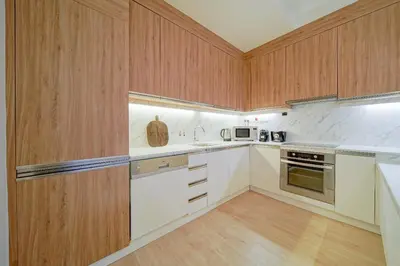 a kitchen with white appliances and wooden cabinets at Luxurious Apartment And Amazing Dubai Marina View in Dubai