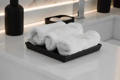 a pile of towels in a black box on a bathroom counter at Luxurious Apartment And Amazing Dubai Marina View in Dubai