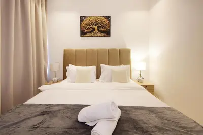 a bedroom with a large white bed with white pillows at Luxury 2BHK Plus Maid's Room The Sterling West Near Dubai Mall in Dubai