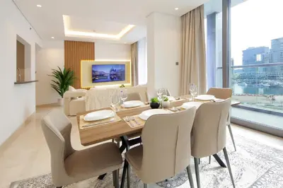 a dining room with a wooden table and chairs at Luxury 2BHK Plus Maid's Room The Sterling West Near Dubai Mall in Dubai