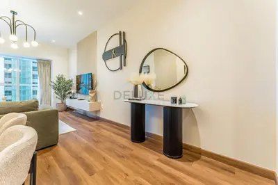 a living room with a table and a mirror at Upgraded 2BR with Partial Sea and City Views Near the Beach, Elite Residence, Dubai Marina by Deluxe Holiday Homes in Dubai