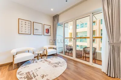 a living room with white furniture and a large window at Upgraded 2BR with Partial Sea and City Views Near the Beach, Elite Residence, Dubai Marina by Deluxe Holiday Homes in Dubai