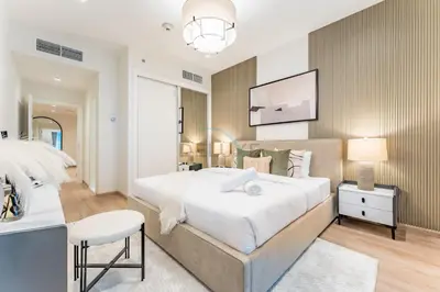a bedroom with a large white bed and a chair at Renovated 1BR with Partial Sea and City Views Close to the Beach, Elite Residence, Dubai Marina by Deluxe Holiday Homes in Dubai