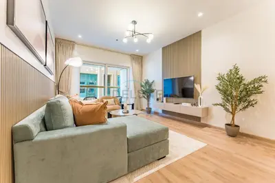 a living room with a couch and a tv at Renovated 1BR with Partial Sea and City Views Close to the Beach, Elite Residence, Dubai Marina by Deluxe Holiday Homes in Dubai