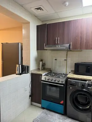 a kitchen with a stove and a refrigerator at Cozy 1Bed Sports city in Dubai