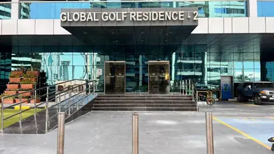 a glass building with doors and stairs in a parking lot at Cozy 1Bed Sports city in Dubai