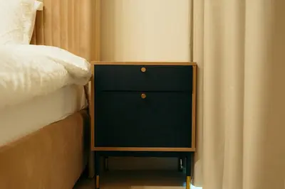 a night stand next to a bed next to a curtain at Luxury 2 bedroom Unit, Prime Location in Dubai