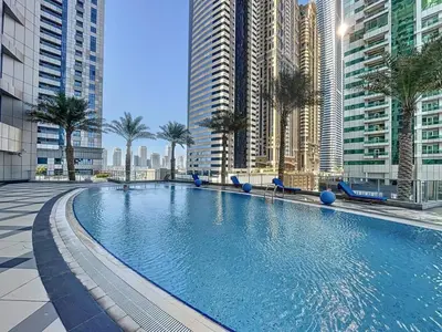 a large swimming pool in a city with tall buildings at Torch Tower - One Bed with Skyline View in Marina in Dubai