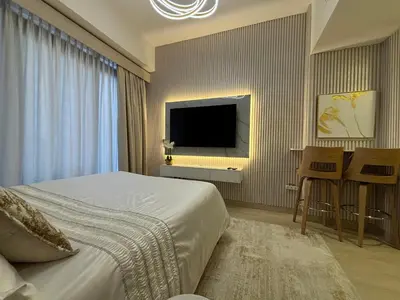 a bedroom with a bed and a flat screen tv at Meydan Riviera Midtown Comfort Studio in Dubai