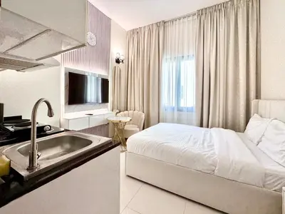 a bathroom with a sink and a bed in a room at Al Manara Premium Cozy Studio in Dubai