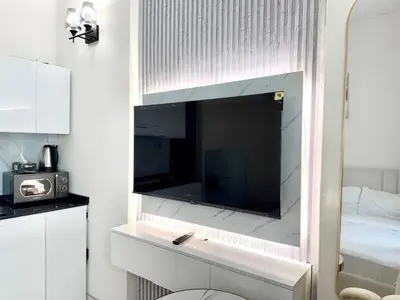 a large flat screen tv on a wall in a bedroom at Al Manara Premium Cozy Studio in Dubai