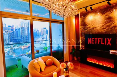 a living room with a fireplace and a chandelier at Barsana - Seaside Luxury 2BDR - Panoramic Marina & Sea Views in Dubai