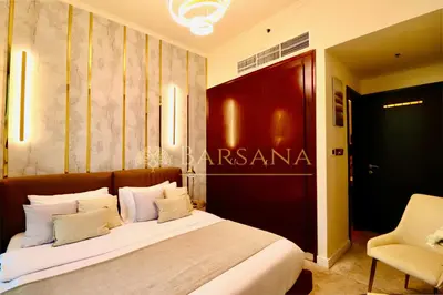 a bedroom with a large bed and a chair at Barsana - Seaside Luxury 2BDR - Panoramic Marina & Sea Views in Dubai