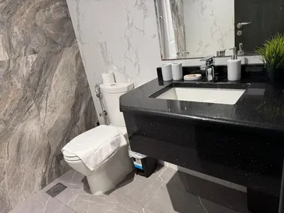 a bathroom with a white toilet and a sink at Chic Studio with Balcony a mins drive to Downtown in Dubai