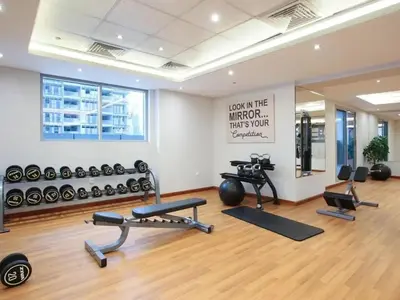 a gym with several exercise equipment in a room at Chic Studio with Balcony a mins drive to Downtown in Dubai
