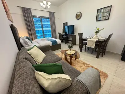 a living room with a couch and a table at Chic Studio with Balcony a mins drive to Downtown in Dubai