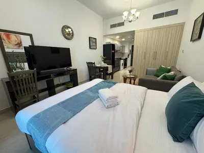 a bedroom with a bed and a living room at Chic Studio with Balcony a mins drive to Downtown in Dubai