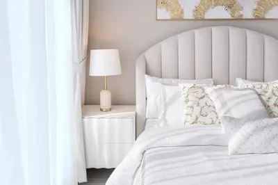 a bedroom with a white bed with a white headboard at 1 Bedroom Marina with Canal View in Dubai