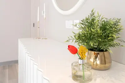 a vase with flowers on a counter in a kitchen at 1 Bedroom Marina with Canal View in Dubai