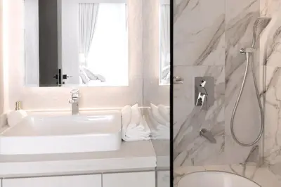 a white bathroom with a sink and a shower at 1 Bedroom Marina with Canal View in Dubai