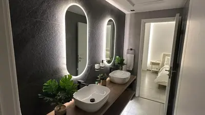 a bathroom with two sinks and two mirrors at Ultimate 5BR Luxury I 2500 sqf I Burj Inner Circle in Dubai