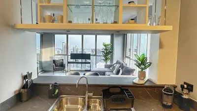 a kitchen with a living room with a large window at Luxury in the Sky - 1BR Burj Inner Circle in Dubai