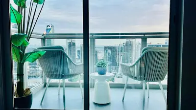 two chairs on a balcony with a view of a city at Luxury in the Sky - 1BR Burj Inner Circle in Dubai