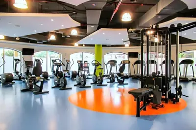 a gym with several treadmills and elliptical machines at Bright and Spacious 2BR with Pool and Gym Access in Dubai