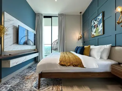 a bedroom with a large bed with blue walls at Trophy-Brandnew Premium and Vibrant 1BR in JVC in Dubai