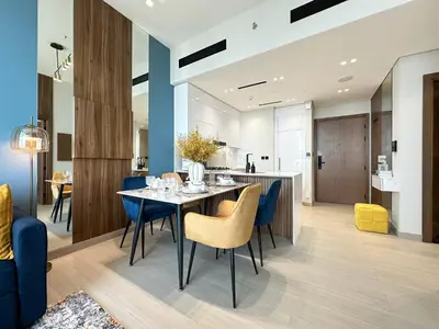 a dining room and kitchen with a table and chairs at Trophy-Brandnew Premium and Vibrant 1BR in JVC in Dubai