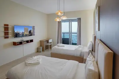 a hotel room with two beds and a window at 28- Luxury Princess Tower Marina Apartment with Sea View, Pool & Balcony in Dubai