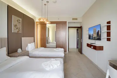 a hotel room with two beds and a tv at 28- Luxury Princess Tower Marina Apartment with Sea View, Pool & Balcony in Dubai