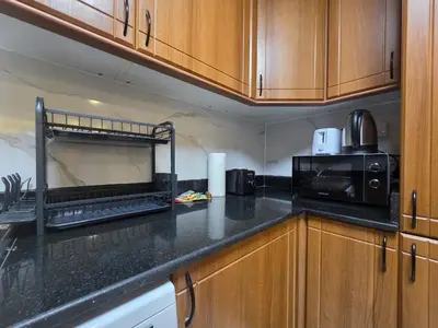 a kitchen with wooden cabinets and a black counter top at 28- Luxury Princess Tower Marina Apartment with Sea View, Pool & Balcony in Dubai