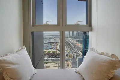 a bed with two pillows in front of a window at 28- Luxury Princess Tower Marina Apartment with Sea View, Pool & Balcony in Dubai