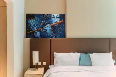a bedroom with a bed with a painting on the wall at Elegant 1-BR with Sea View Seven Palm, Palm Jumeirah in Dubai