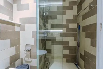 a bathroom with a glass shower with a sink at Elegant 1-BR with Sea View Seven Palm, Palm Jumeirah in Dubai