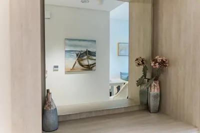 a mirror in a room with a picture of a boat at Elegant 1-BR with Sea View Seven Palm, Palm Jumeirah in Dubai