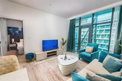a living room with a couch and a tv at Elegant 1-BR with Sea View Seven Palm, Palm Jumeirah in Dubai