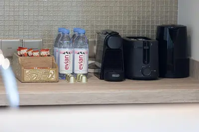 a shelf with two bottles of water and a coffee maker at Mahogany 4 - 2BR 6PAX - Panoramic Burj Khalifa View in Dubai