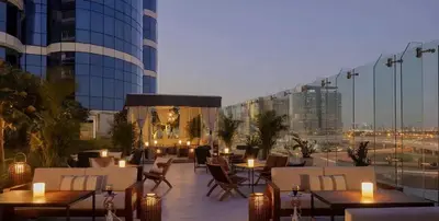 a rooftop patio with tables and chairs on a building at Mahogany 4 - 2BR 6PAX - Panoramic Burj Khalifa View in Dubai