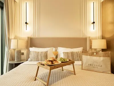 a bedroom with a bed with a tray of food on a table at Burj Royale Suites by Prestige Nest in Dubai