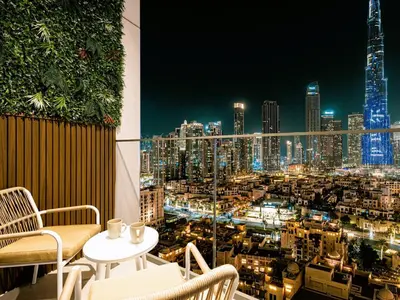 a balcony with a view of a city at night at Burj Royale Suites by Prestige Nest in Dubai